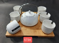 Kettle with cups on wooden tray